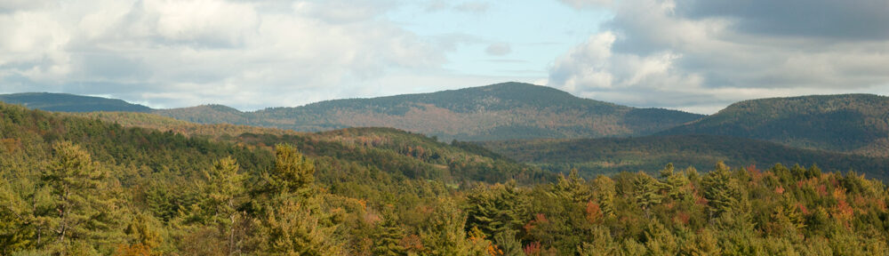 View of mountains in fall with cloudy sky.